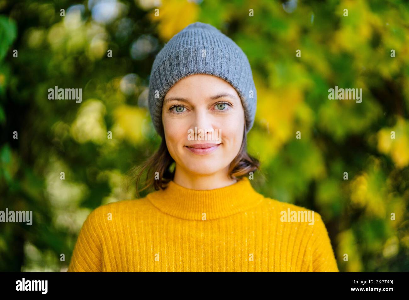 Smiling woman standing with knit hat Stock Photo