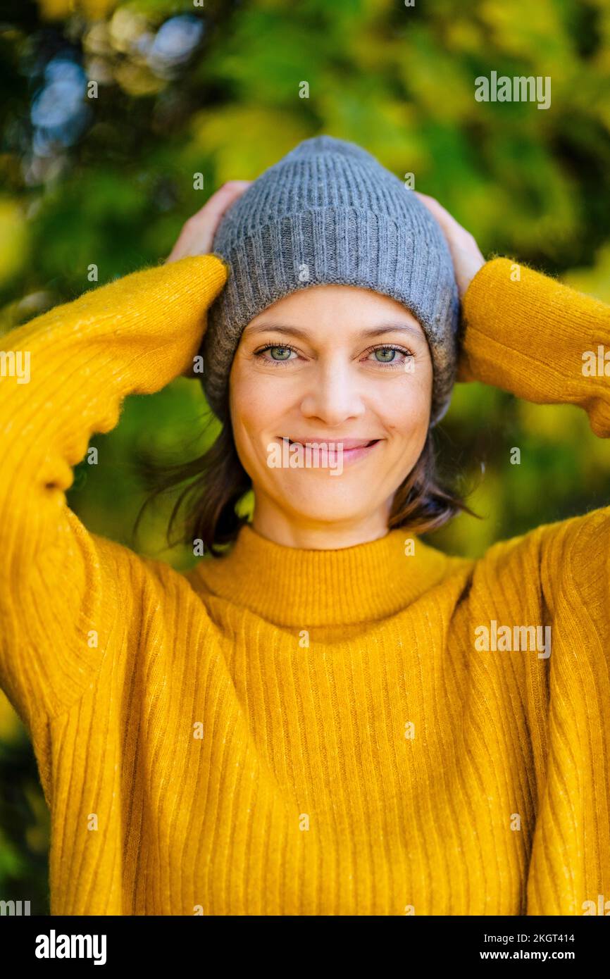 Happy woman standing with knit hat Stock Photo