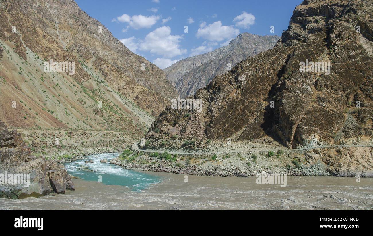 Scenic landscape view of colorful turquoise stream flowing from Afghanistan joining the Panj river valley, Darvaz, Gorno-Badakshan, Tajikistan Pamir Stock Photo