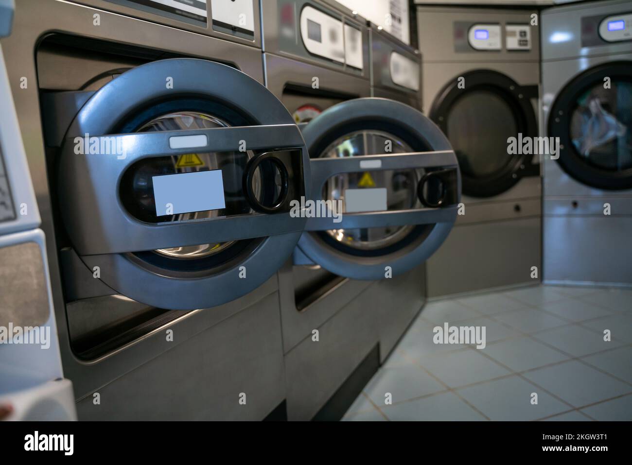 Shared laundry room with several front-loading washing machines Stock Photo