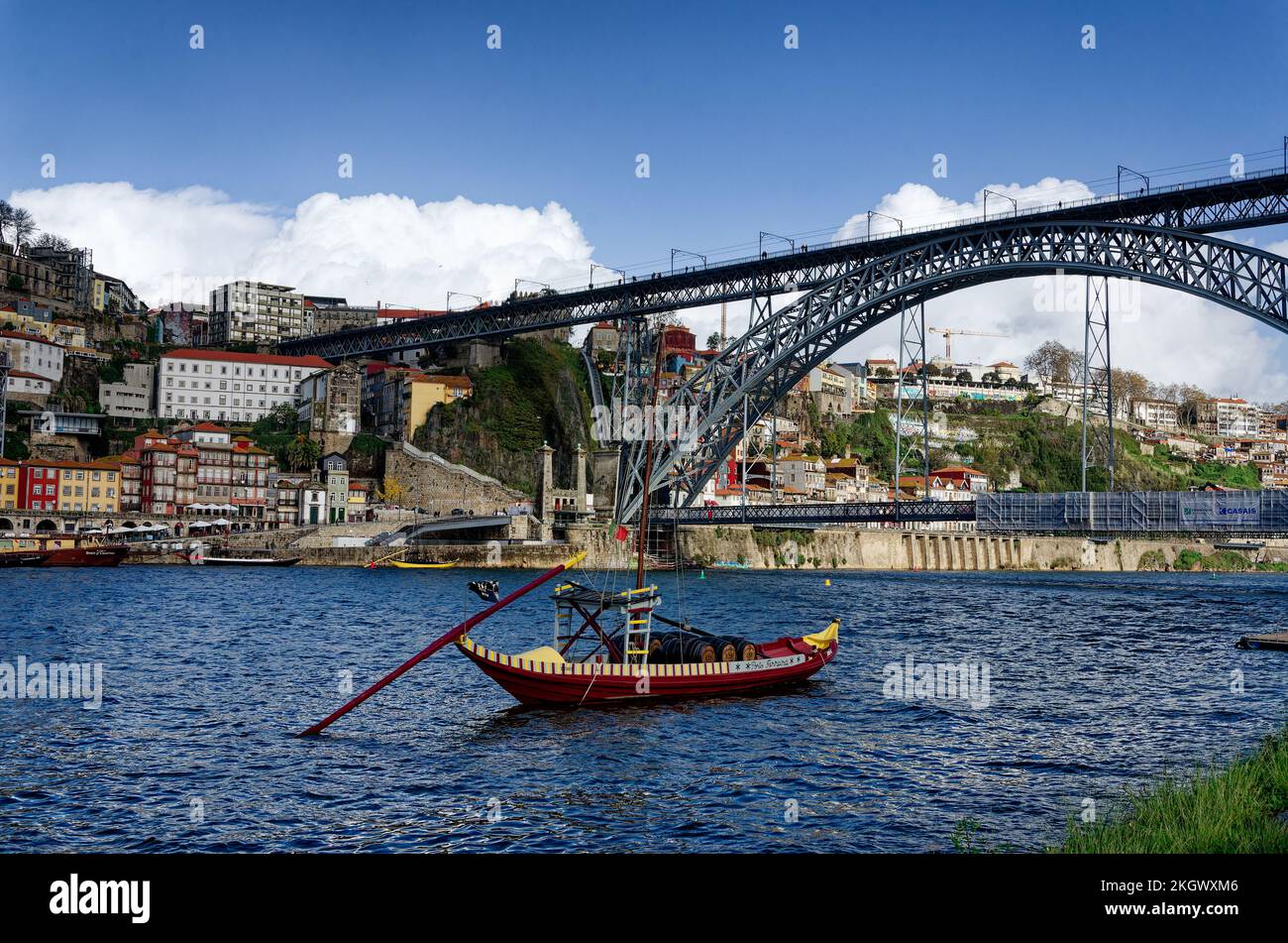 Wine seller boat in from of the Dom Luis Bridge designed by Gustavo Eiffel spanning the River Douro from Porto to Gaia, Portugal Stock Photo