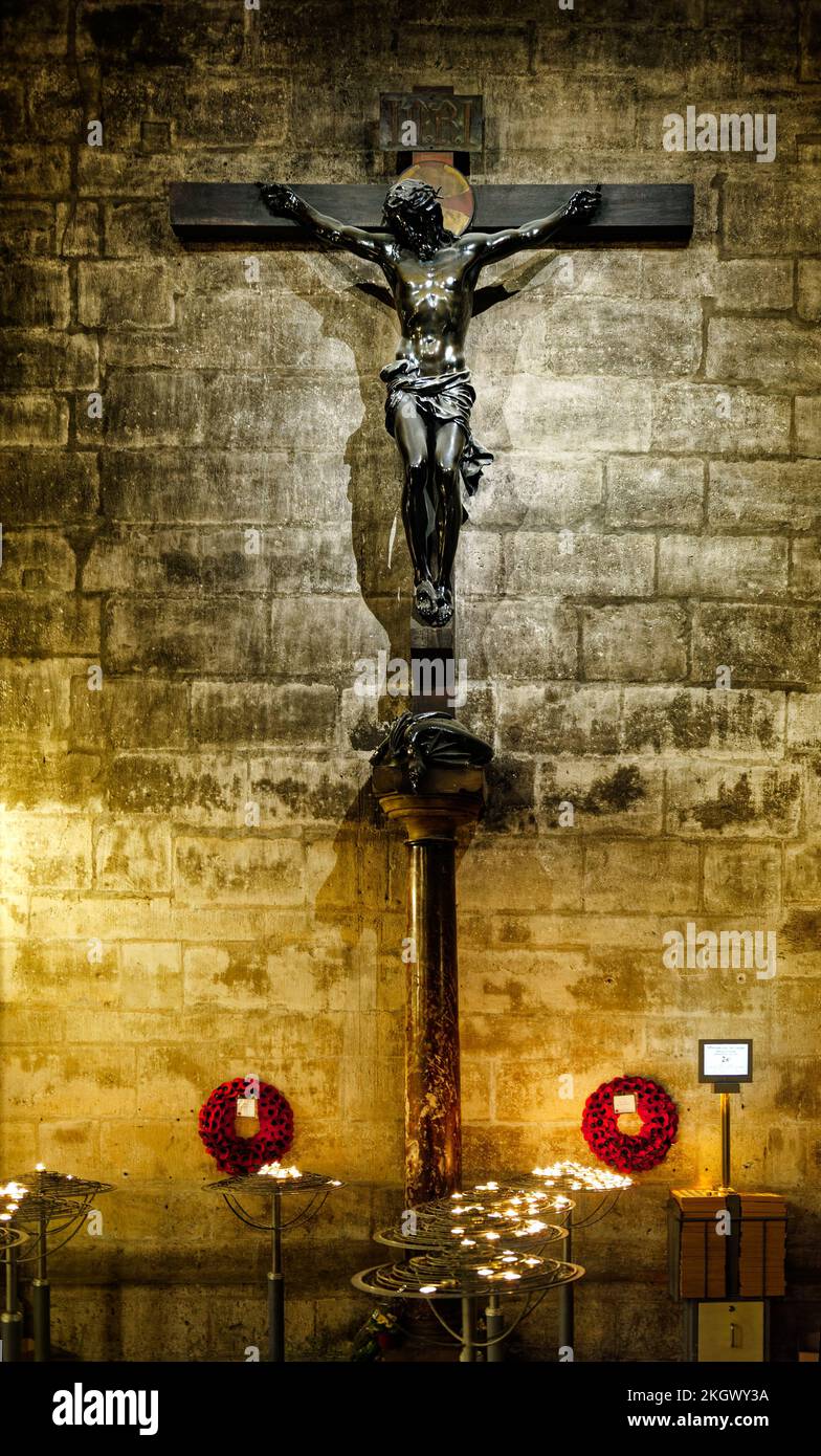 Statue of the crucifixion of Jesus Christ on the cross inside Notre Dame Cathedral, Paris, France with candles Stock Photo