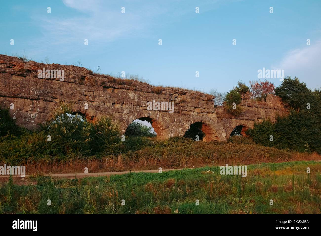 Ancient aqueducts at Parco Degli Acquedotti. Stone arches built to carry water into the city during the Roman Empire. Outdoor park in Rome, Italy. Stock Photo
