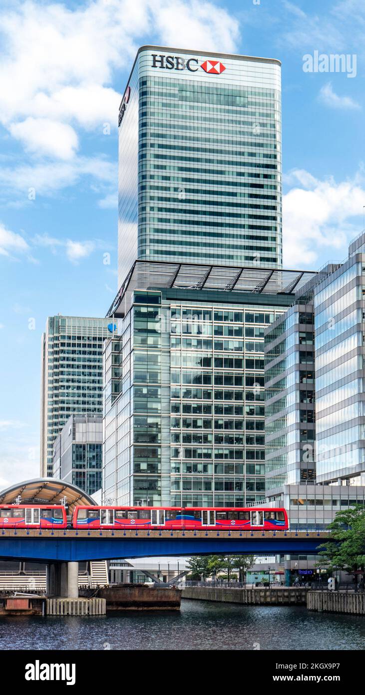 Canary Wharf HSBC blue sky reflected at North Dock with HSBC building and West India Quay station cross rail underground train London E14 Stock Photo