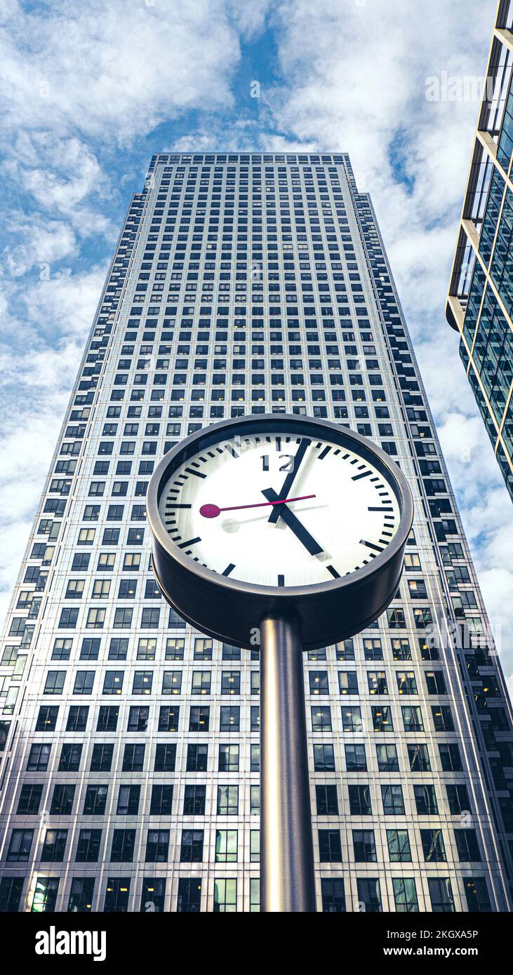 TIME BUSINESS OFFICES SKYSCRAPER TOWER Canary Wharf clock at 5.03 pm  (17.03 pm) wih One Canada Square tower building behind Canary Wharf London UK Stock Photo