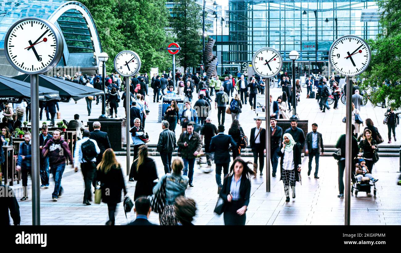 COMMUTERS CROWDS TIME CANARY WHARF CLOCKS LONDON 17.08 commuting Canary Wharf Cross Rail Underground Tube Station South Colonnade with Swiss white face clocks displaying accurate commuting timing. Office workers making the daily commute back home at the end of the working day Canary Wharf London UK Stock Photo
