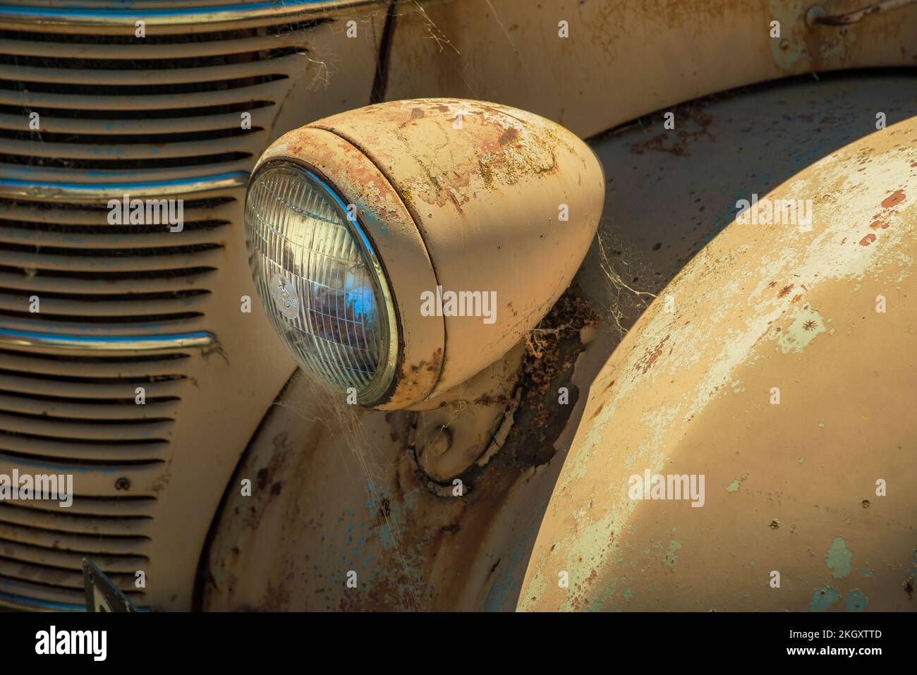 A rusty headlamp, front fender and grille of an old brown International truck Stock Photo