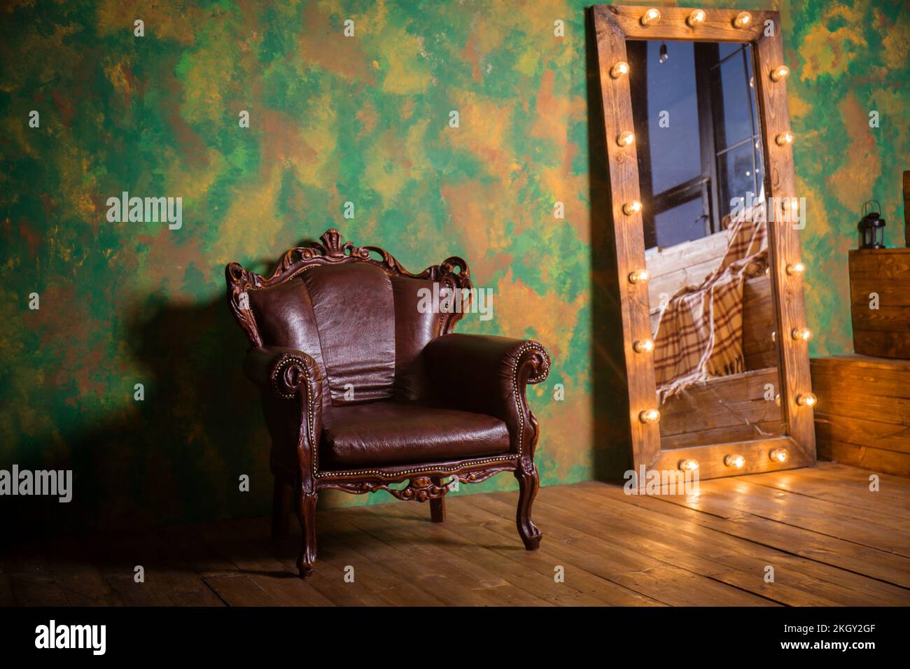 A beautiful vintage leather armchair with wooden details on a green