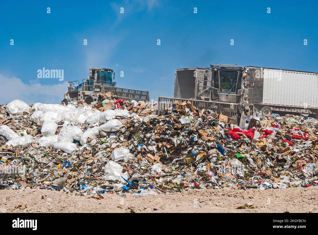Two soil compactors and two semi trailers on a hill in an active landfill Stock Photo Alamy