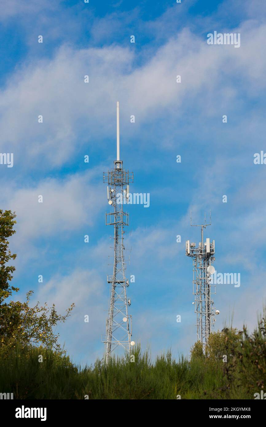 Tall UK mobile phone masts outdoors in sunshine with blue sky