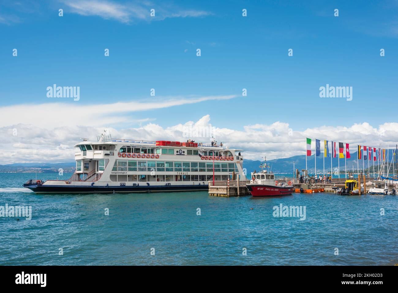 Lake Garda ferry, view in summer of a ferry boat leaving the lakeside town of Bardolino in Lake Garda, Veneto, Italy Stock Photo