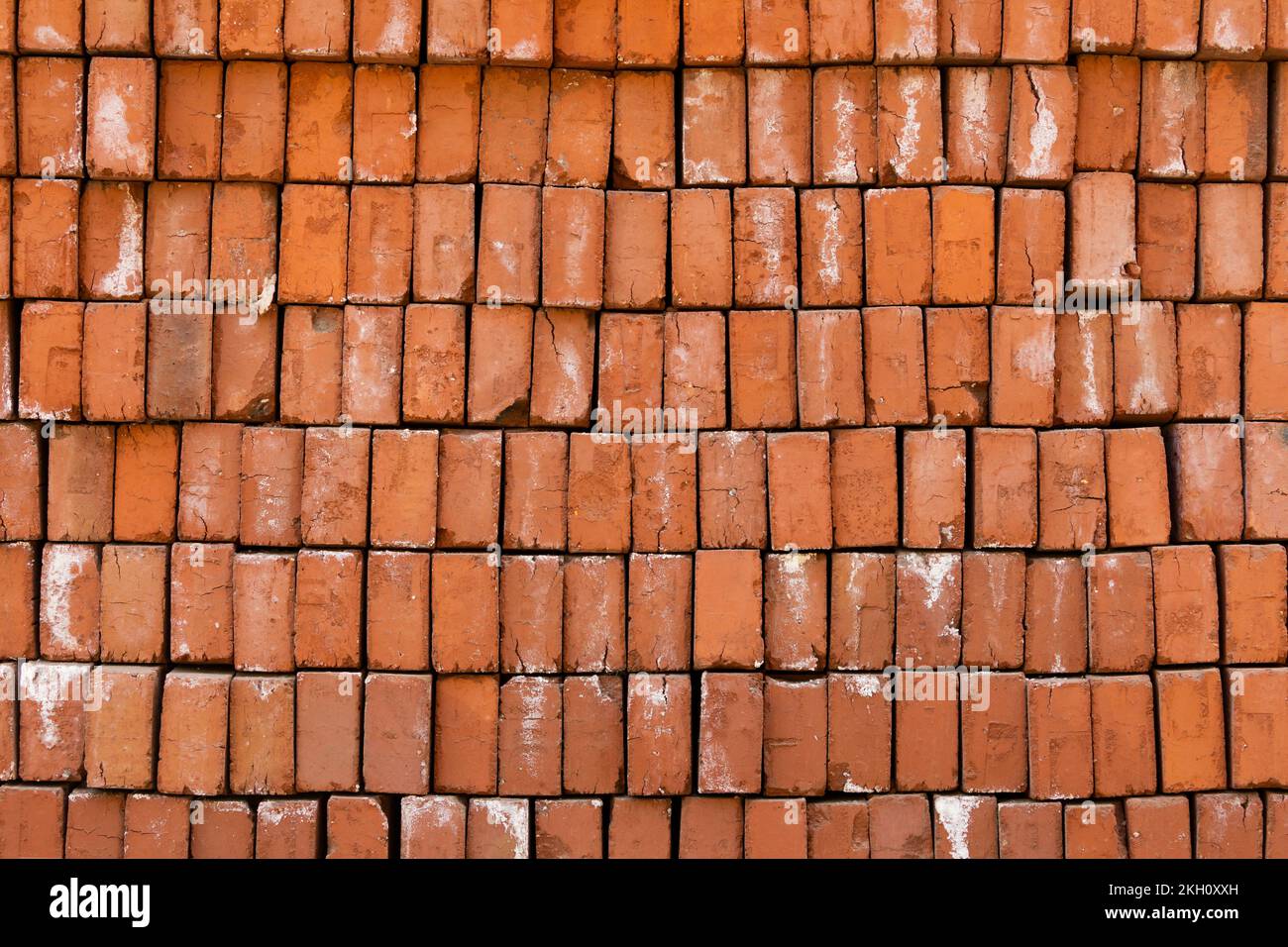 Textured background of fired bricks, handmade, irregular and cracked some on a street in Luang Prabang, Laos Stock Photo