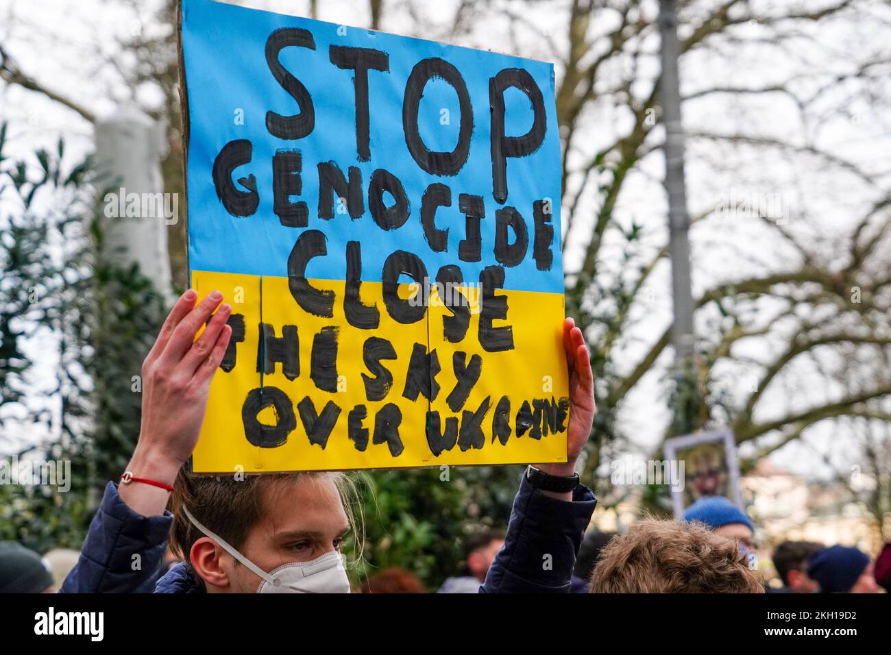 A young man holds a sign 'Stop Genocide. Close the Dky over Ukraine.' Stock Photo