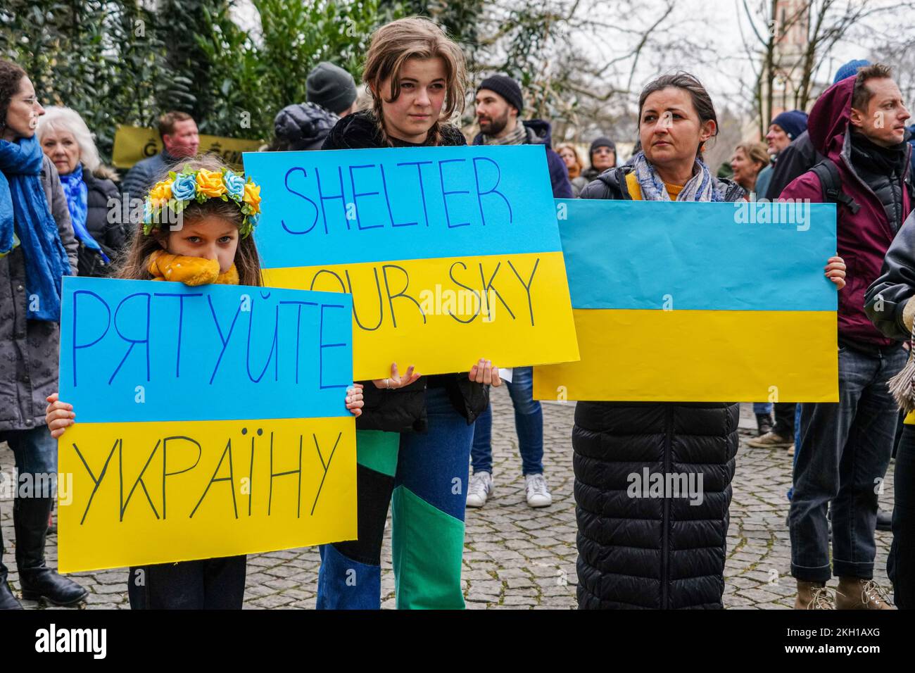 A Ukrainian mother with her two children. The older one carries a sign: 'Shelter our Sky'. Stock Photo