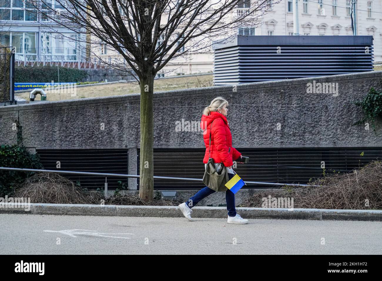 A demonstrator with a small Ukrainian flag on her way home after the end of the demonstration against Putin's war in Ukraine. Stock Photo