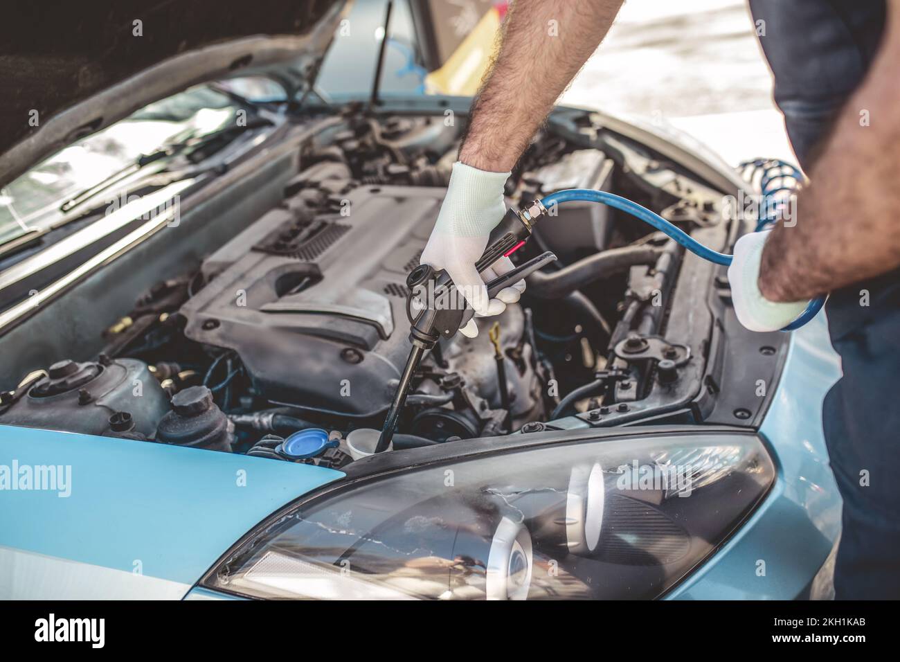 Experienced service station worker washing a customer car Stock Photo