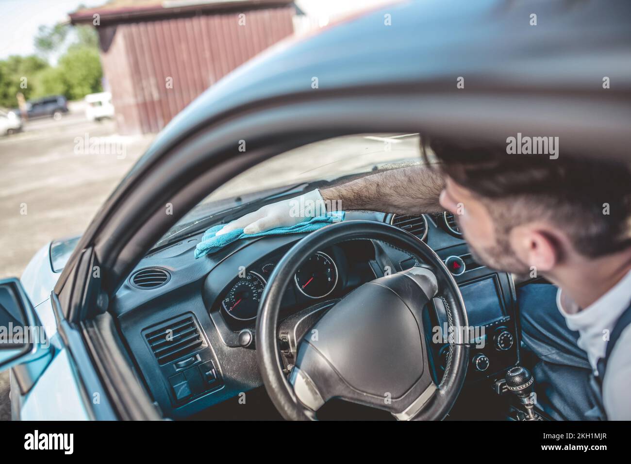 Auto detailer cleaning an instrument panel of a client vehicle Stock Photo