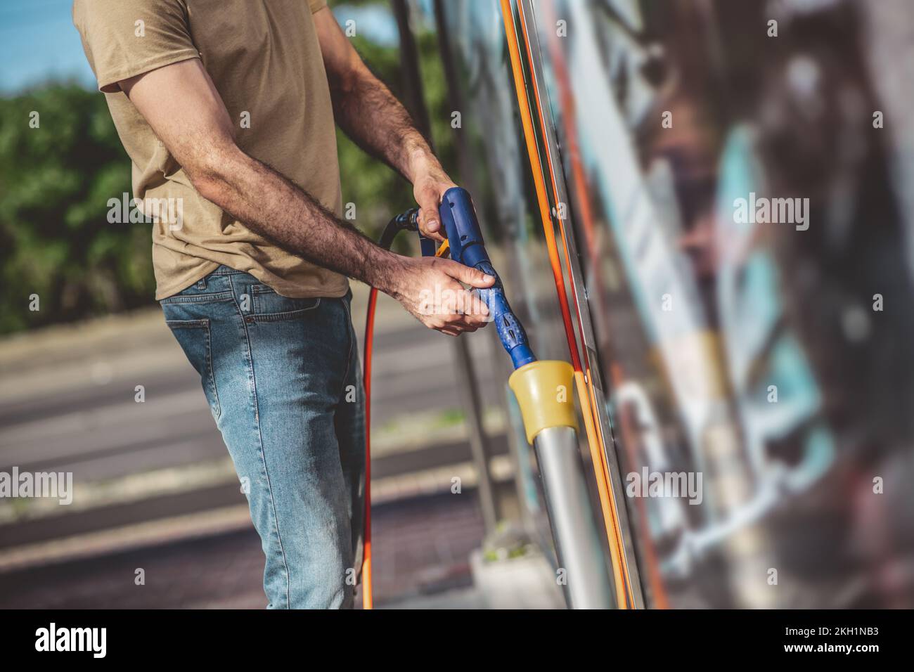 Experienced service station worker preparing for a car washing procedure Stock Photo