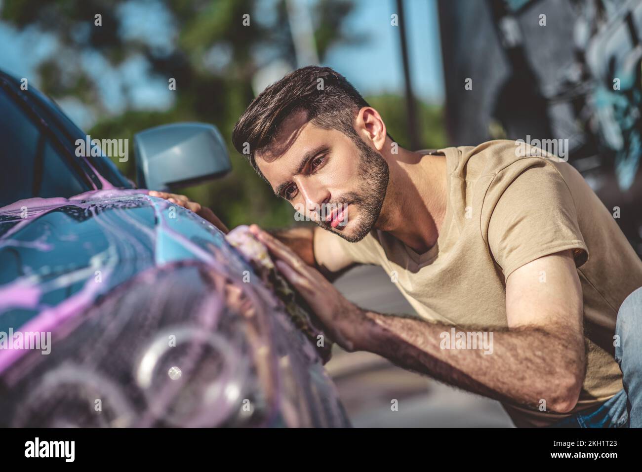 Concentrated service station worker washing a client vehicle Stock Photo