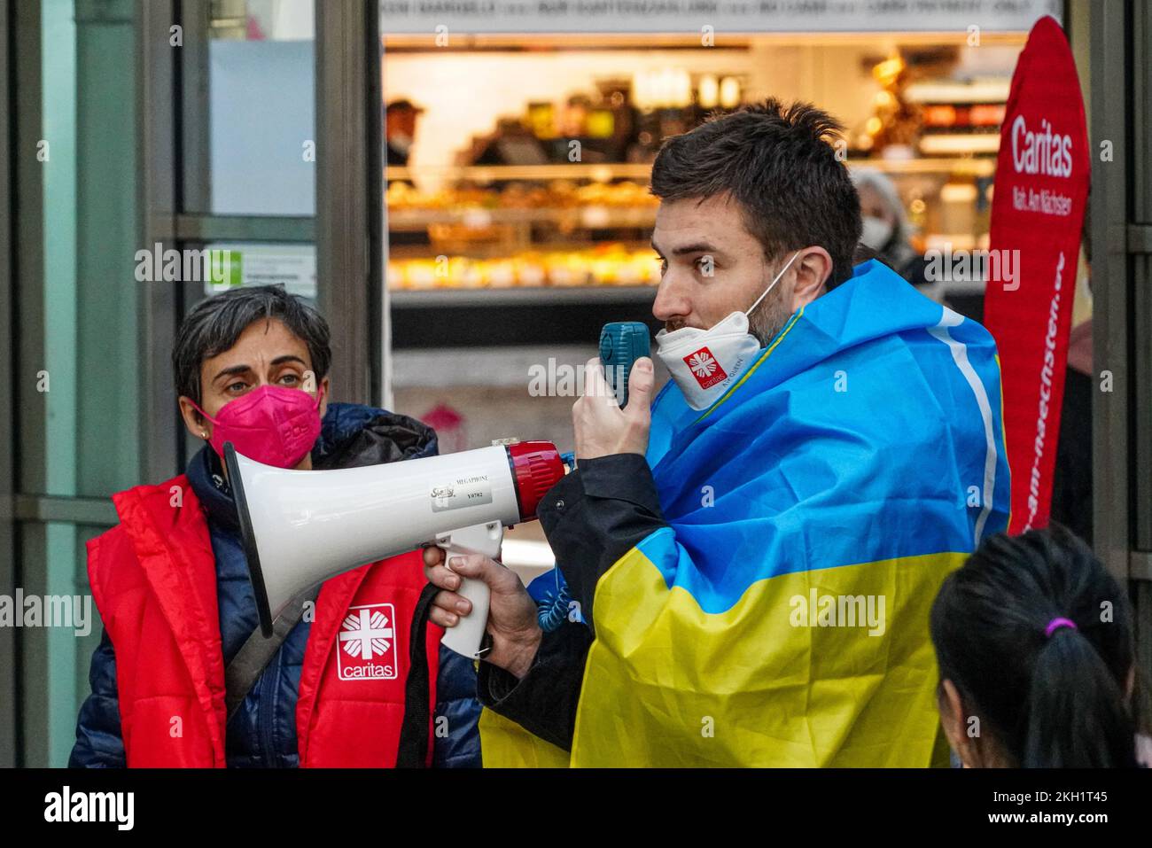 A volunteer uses a megaphone to give information to the Ukrainian people seeking help. Stock Photo