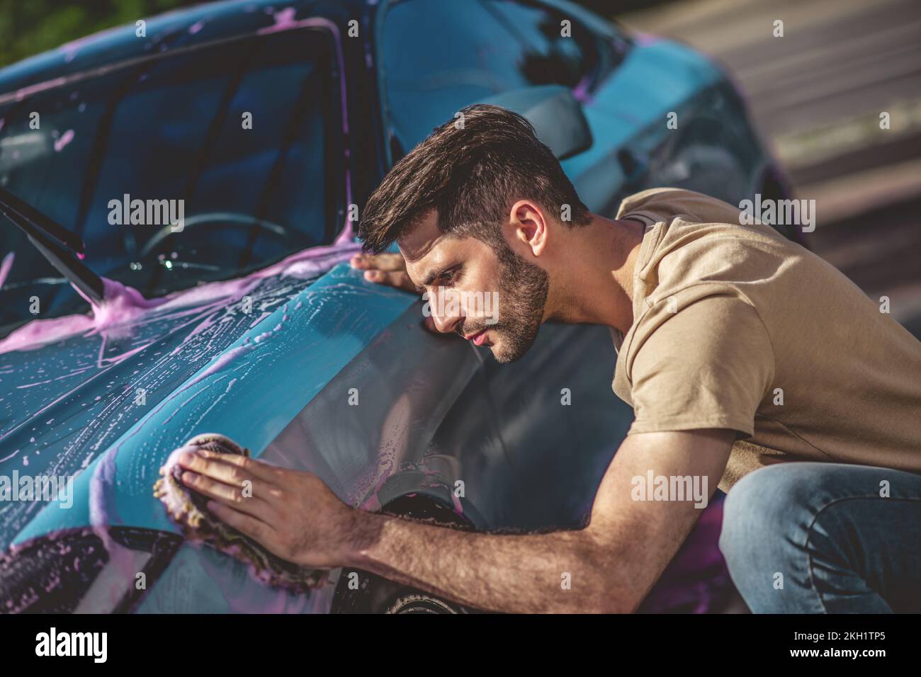 Service station worker cleaning the outside of a motor vehicle Stock Photo