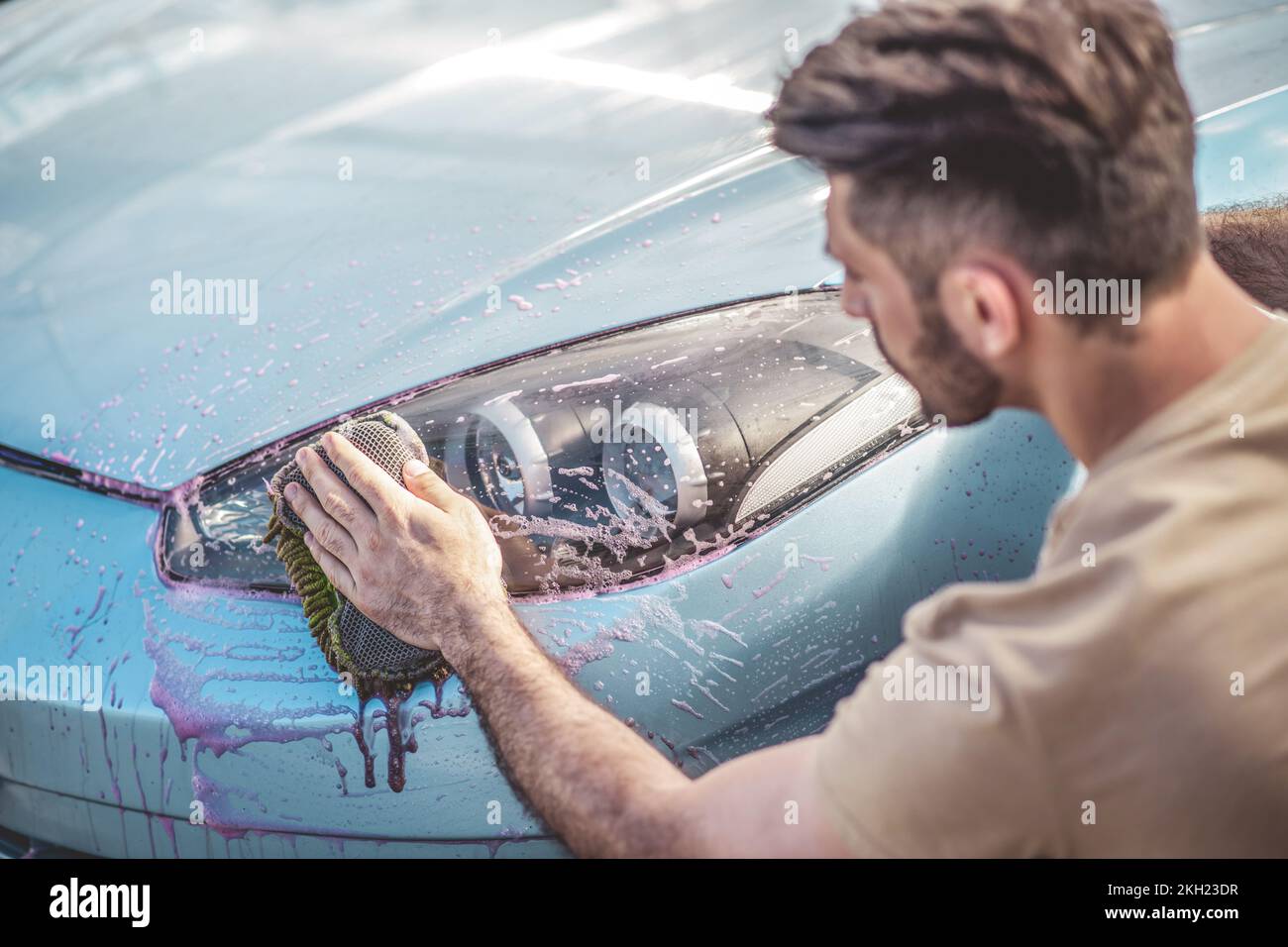 Focused car detailing professional washing the automobile headlight Stock Photo