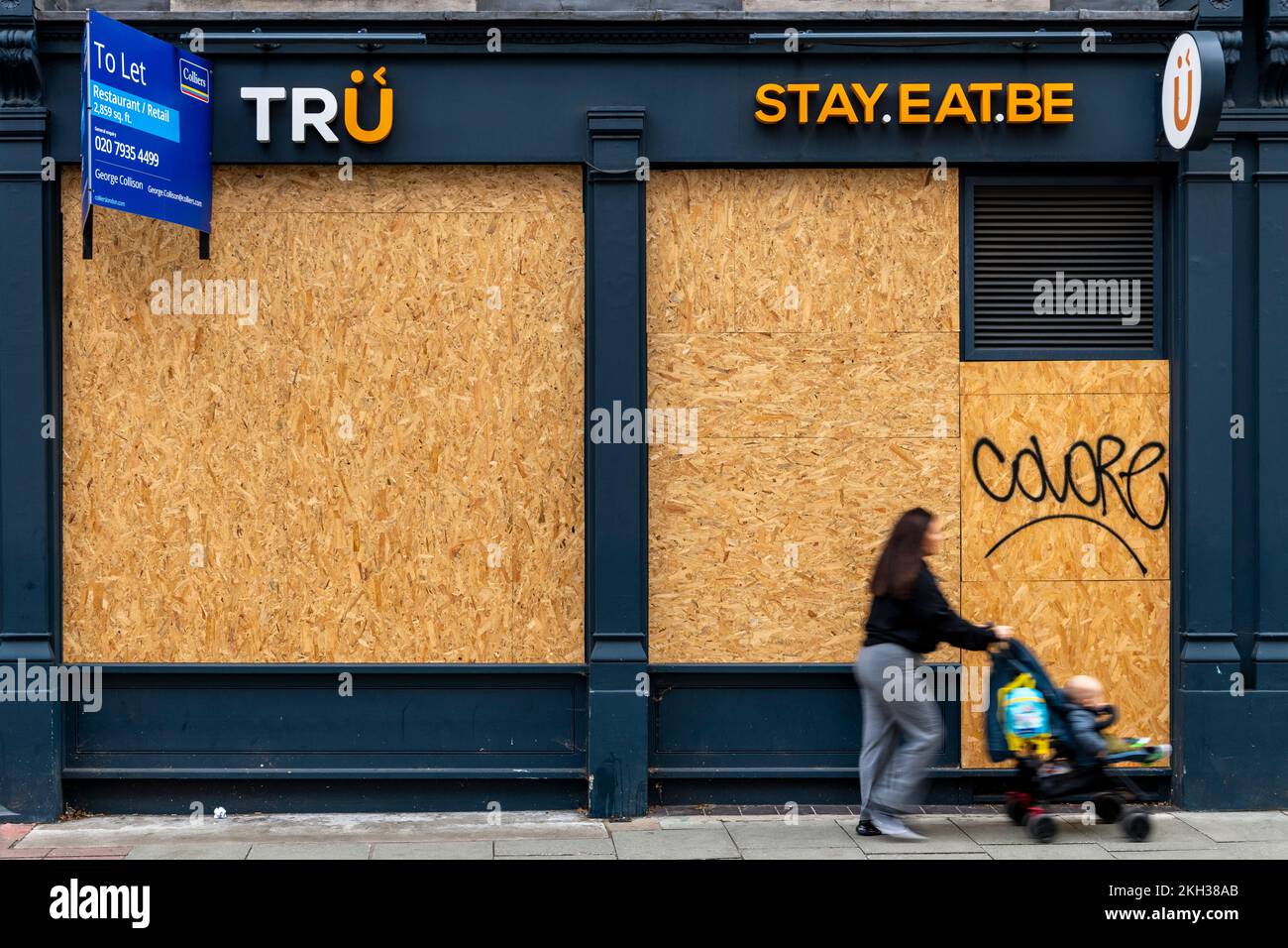 People walking past a closed down and boarded up restaurant / cafe, High Holborn, London, UK.  22 Oct 2022 Stock Photo
