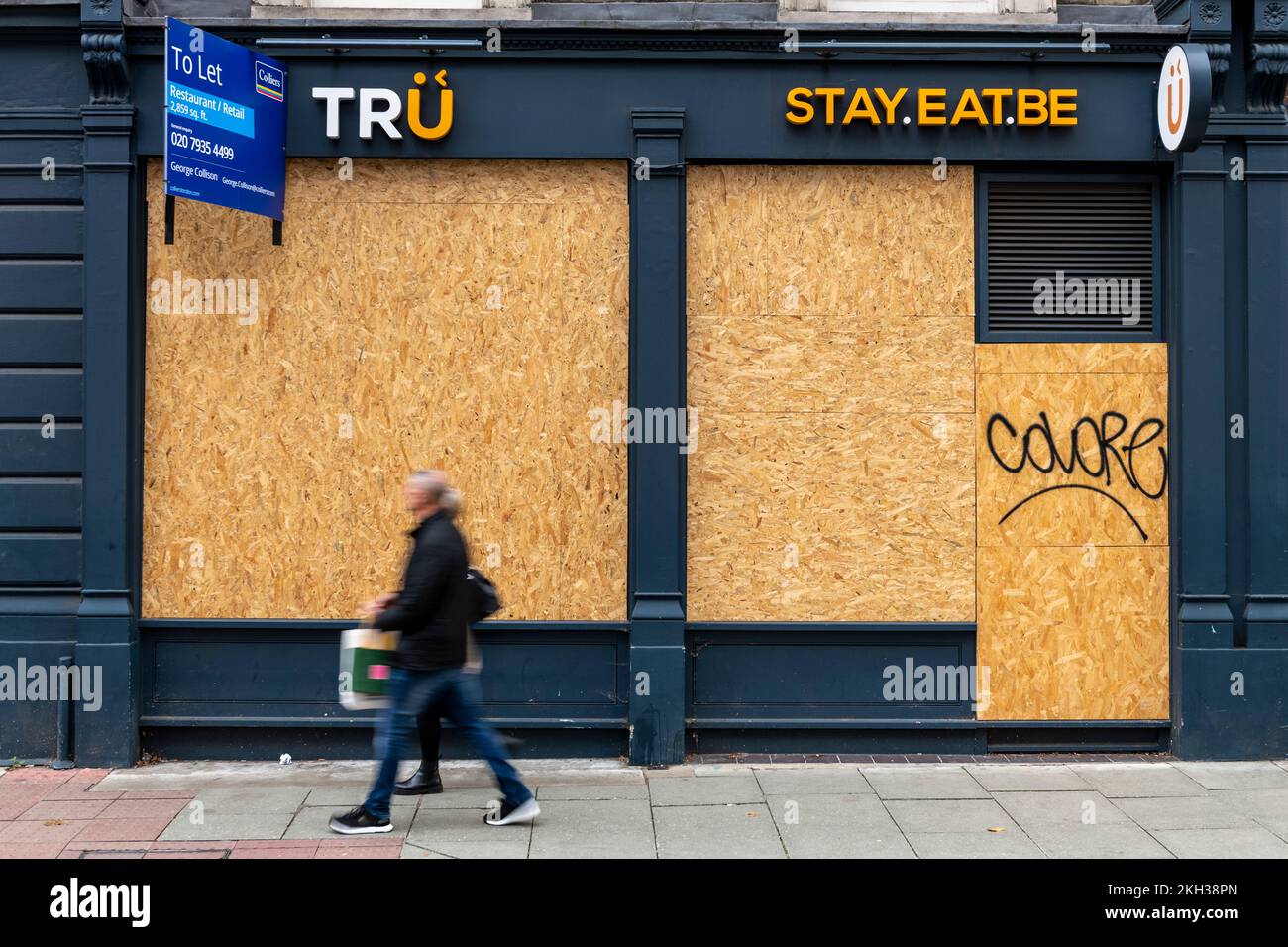 People walking past a closed down and boarded up restaurant / cafe, High Holborn, London, UK.  22 Oct 2022 Stock Photo