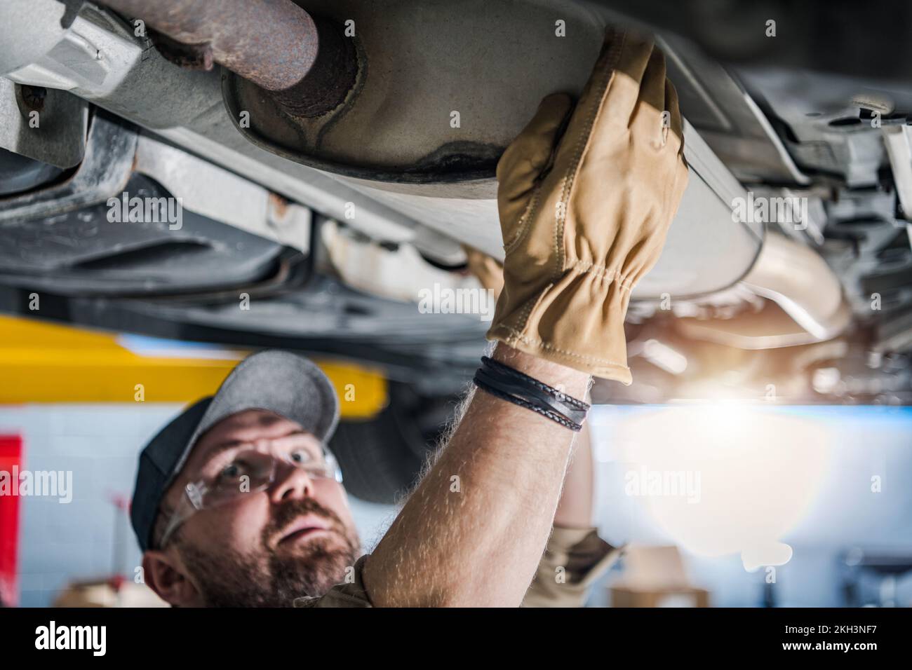 Closeup of Car Catalytic Converter Being Checked by Professional
