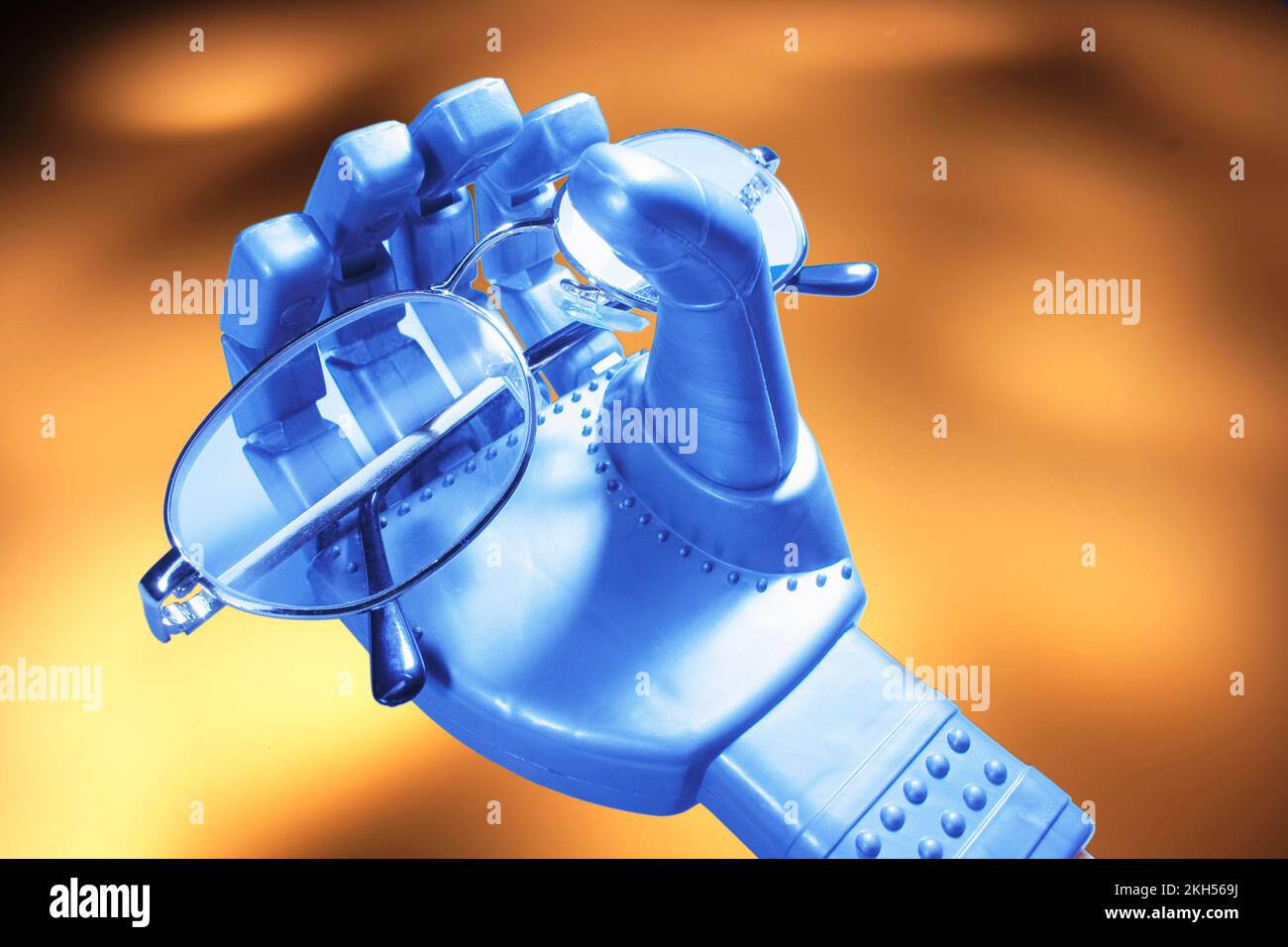Robotic Hand with Eyeglasses on Warm Background Stock Photo