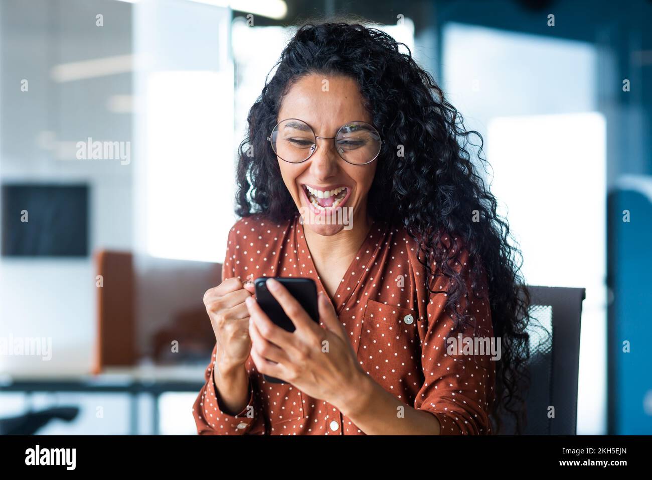 Happy and joyful hispanic business woman working inside office reading ...