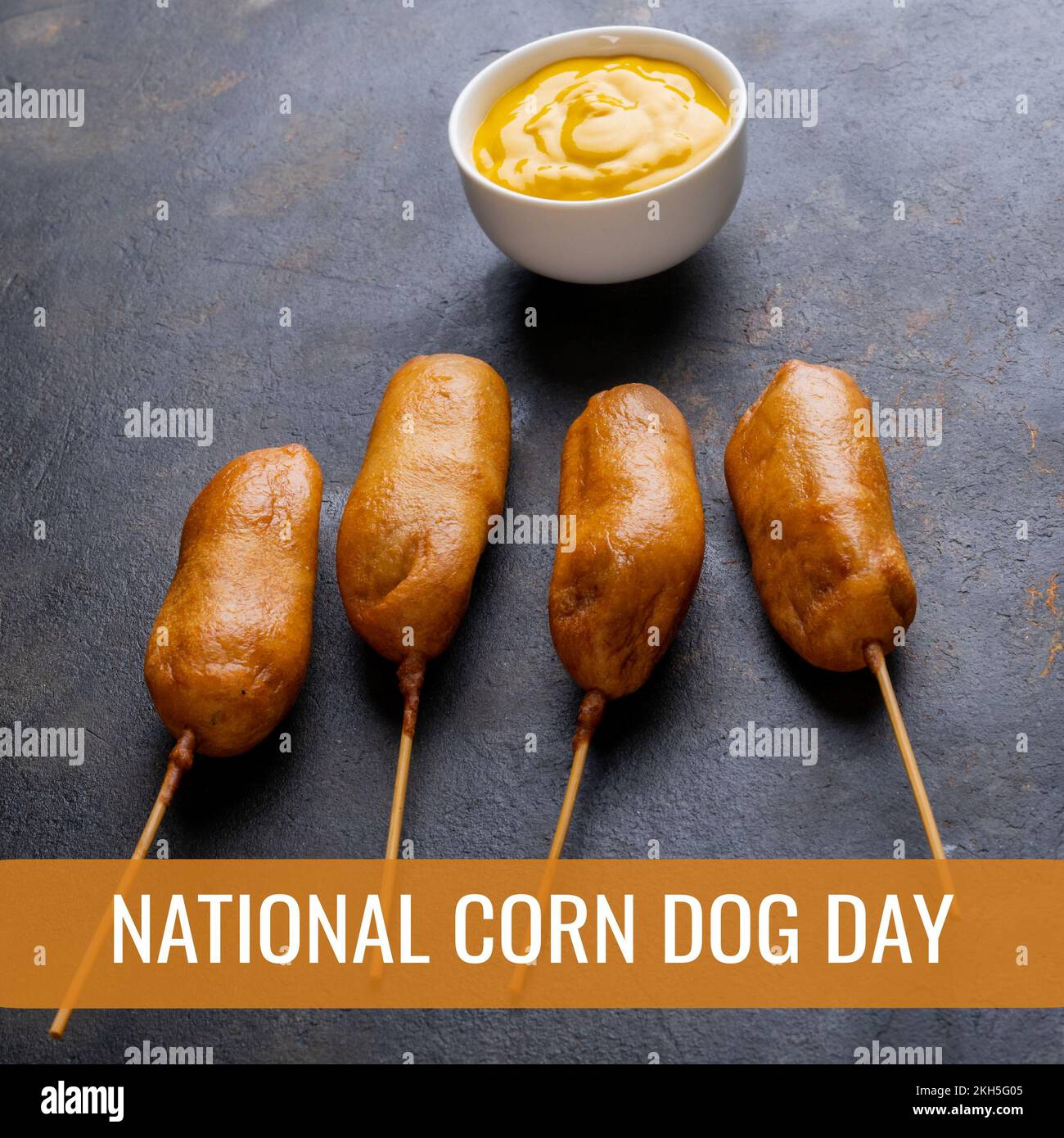 Composition of national corn dog day text over corn dogs on grey