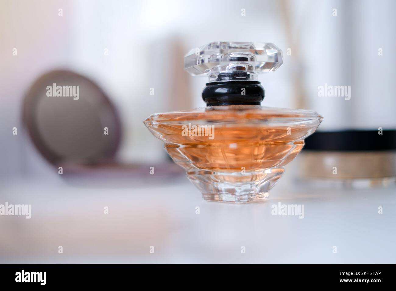 A perfume bottle surrounded by beauty products, powder, lotion Stock