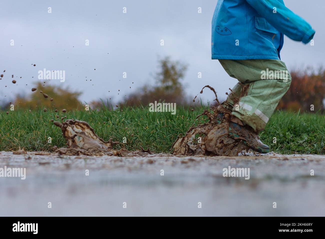 Jumping in mud puddles, it splashes properly Stock Photo