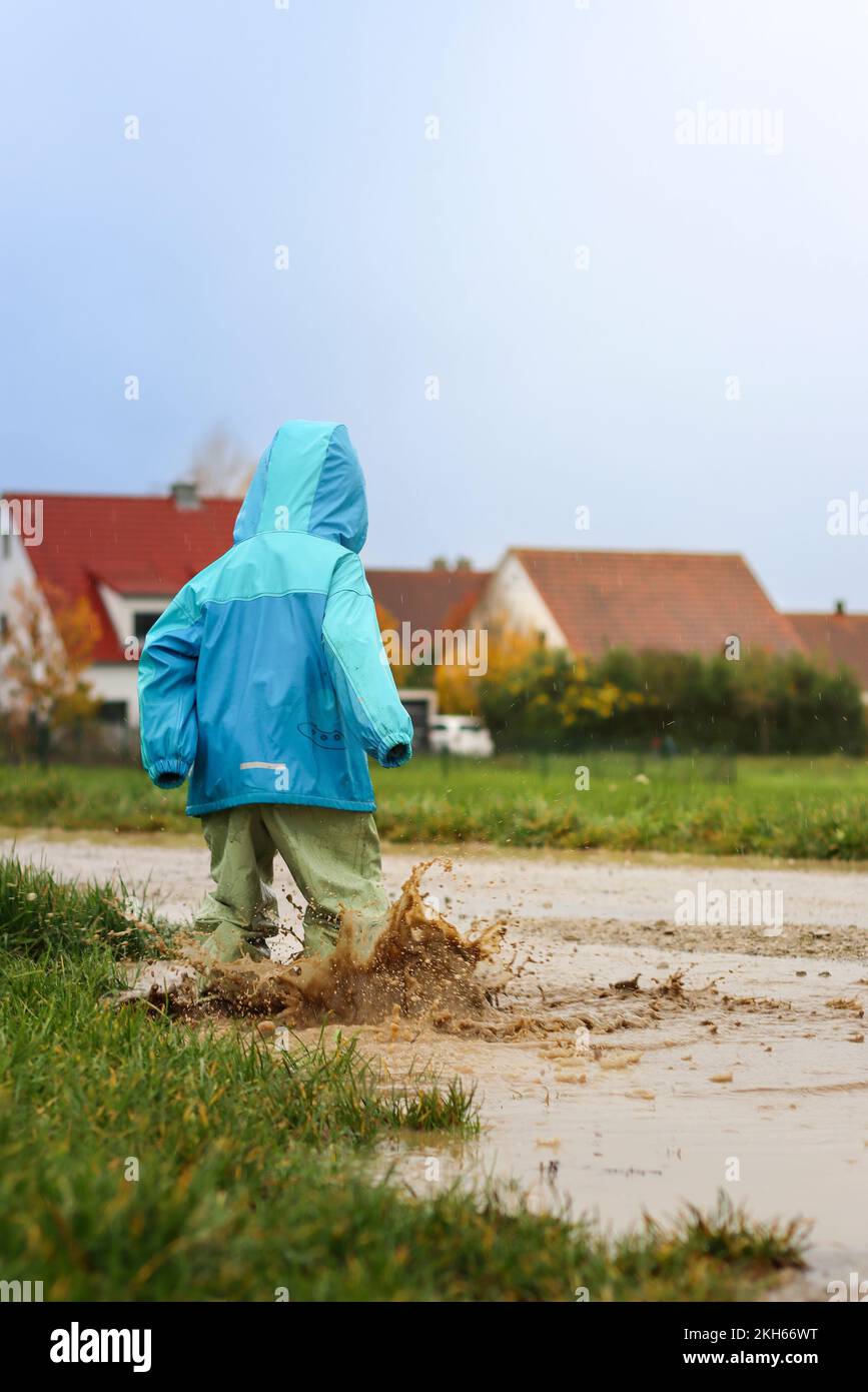 Jumping in mud puddles, it splashes properly Stock Photo