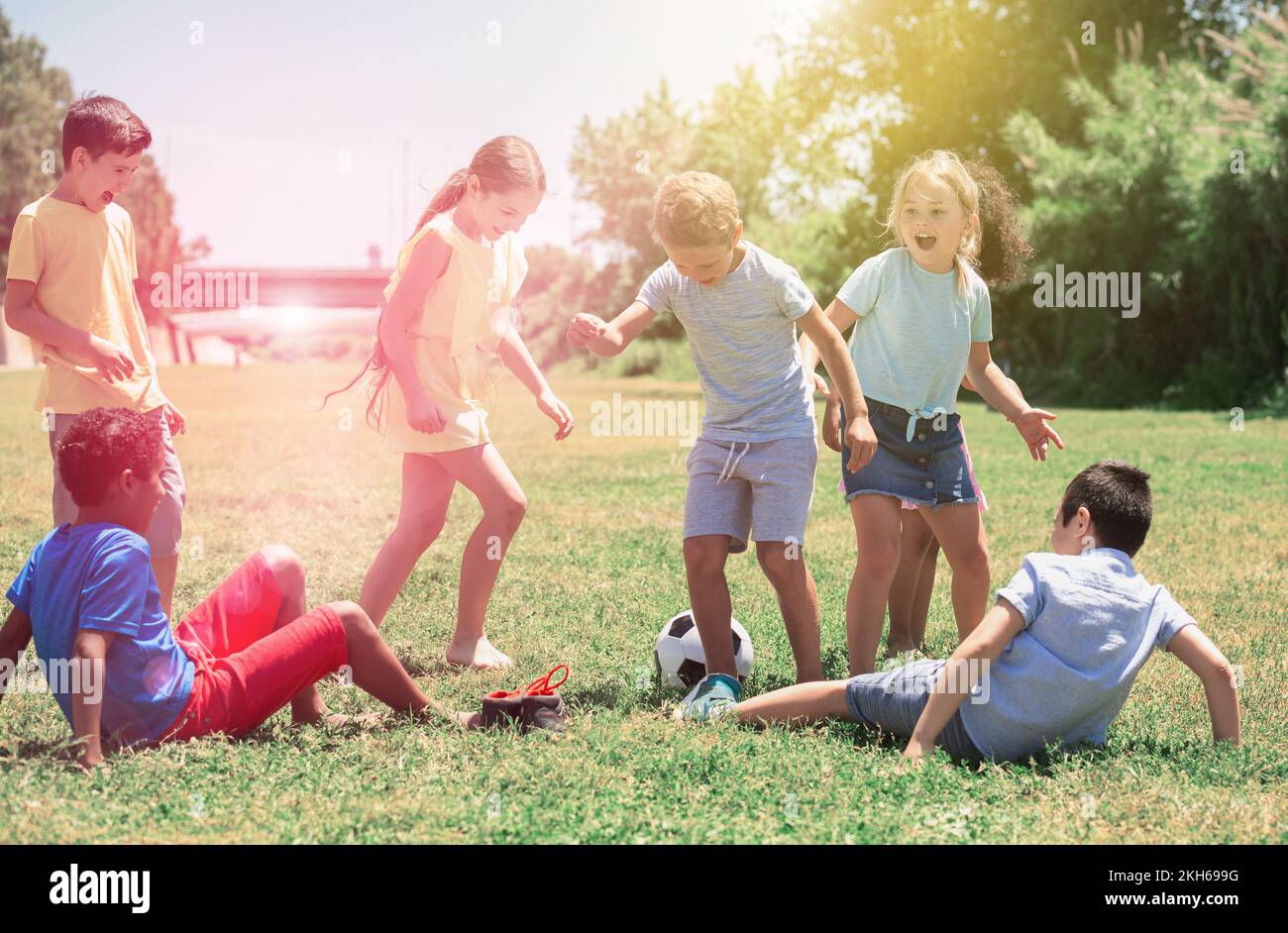 Company of glad children playing football on the playground Stock Photo ...