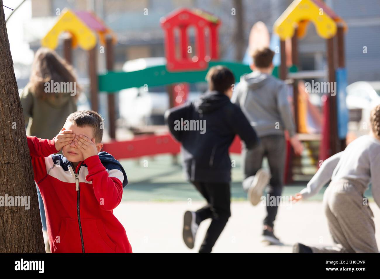 Boy Playing Hide And Seek With Friends Stock Photo - Alamy