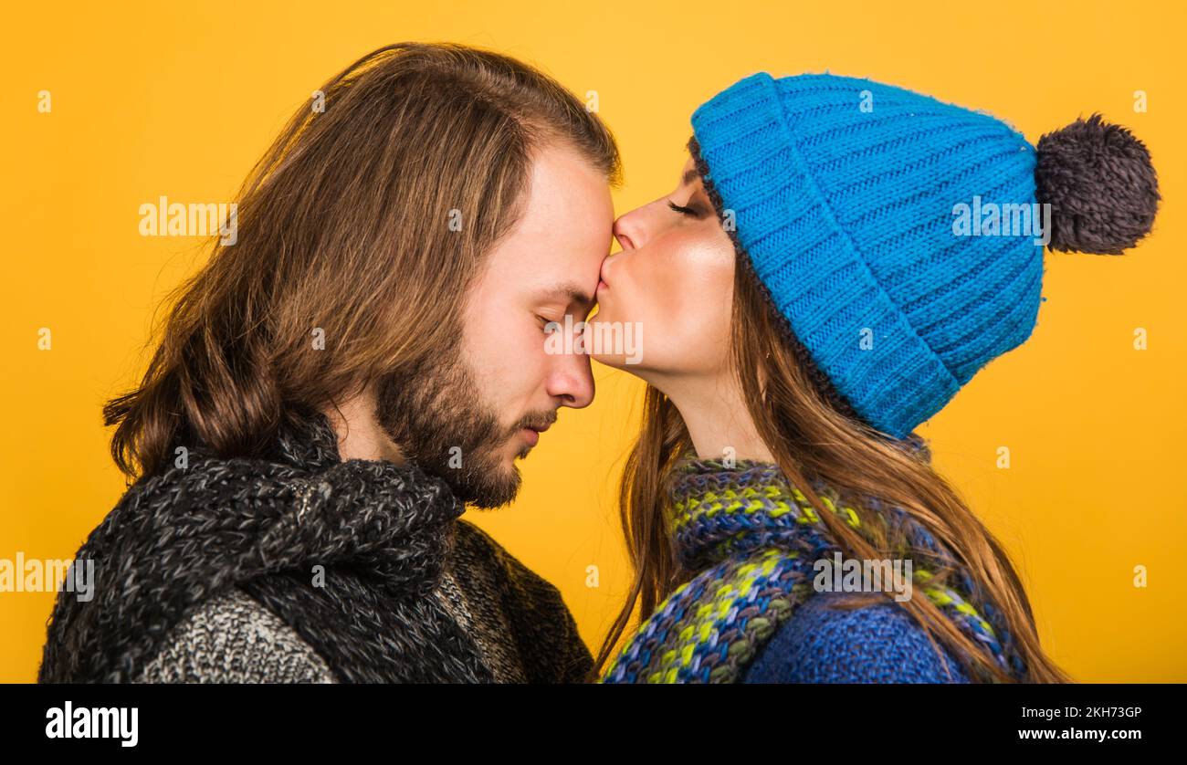 Lovely couple in warm clothes. Autumn or winter time. Woman kisses man in forehead. Stylish family. Stock Photo