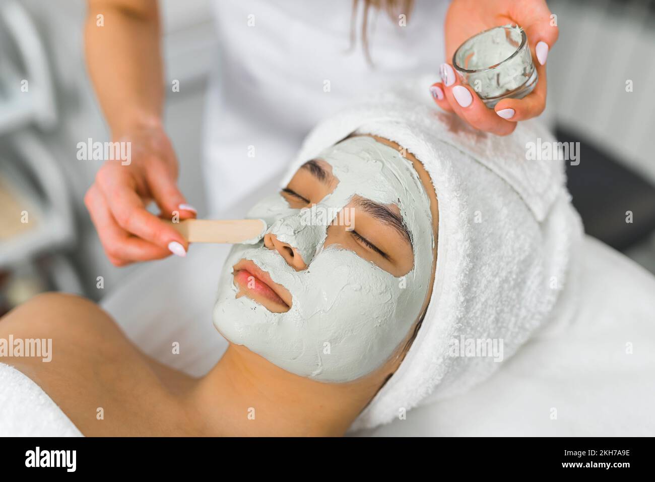 professional putting facial mask for her client at the beauty center, closeup side view beauty treatment. High quality photo Stock Photo