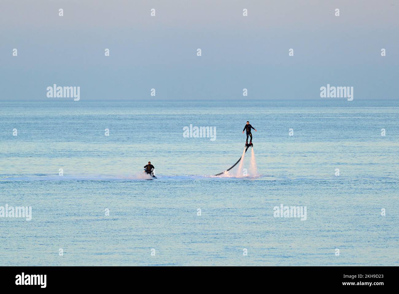 A person using a water jet pack in a calm sea Stock Photo