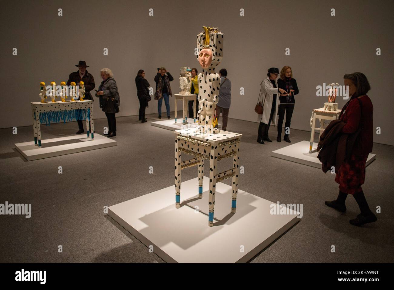 People observe art pieces during the inauguration of the exhibition of