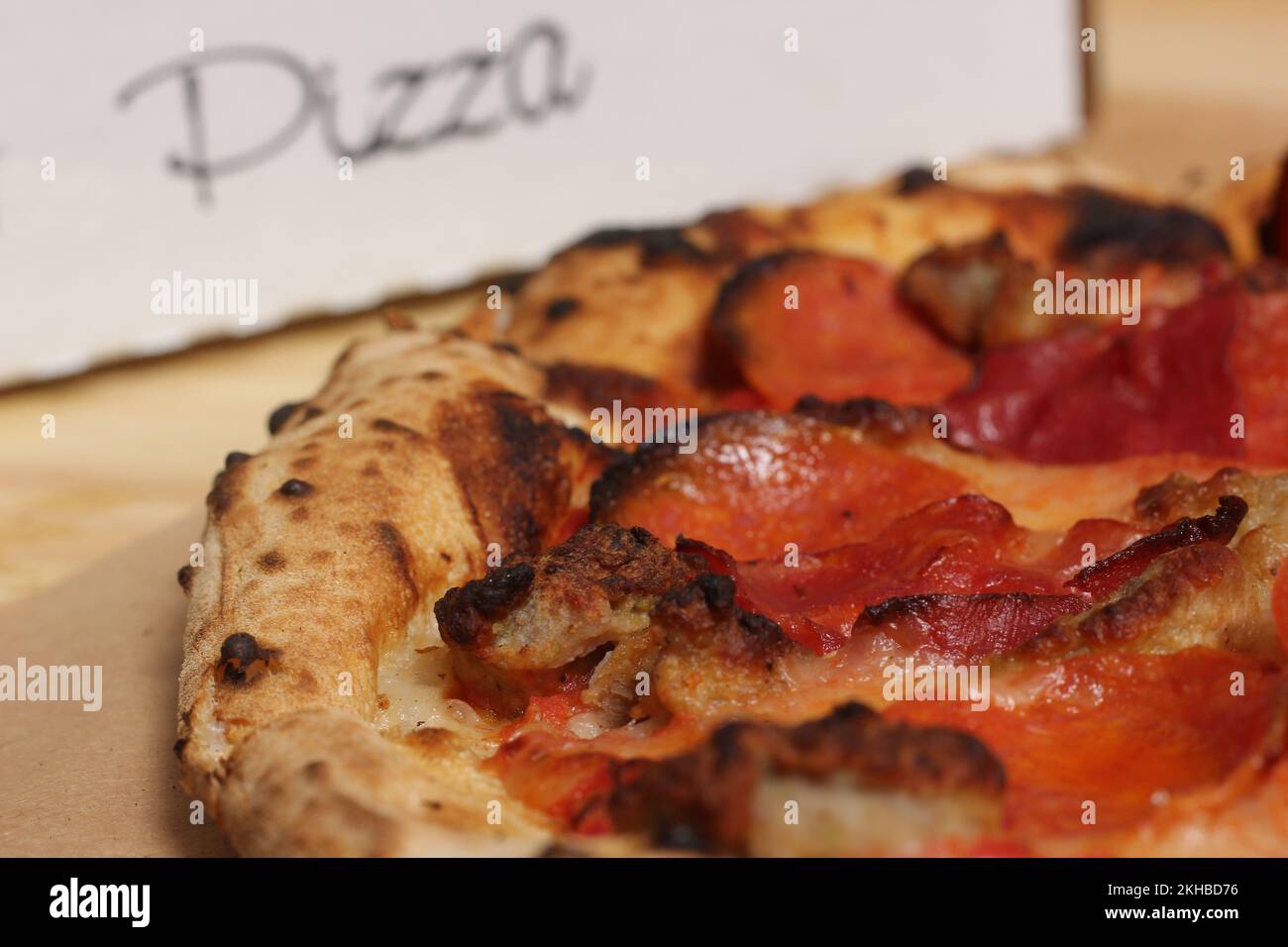 Fresh Pizza on Wooden Table at Restaurant Sliced and Ready to Enjoy Stock Photo