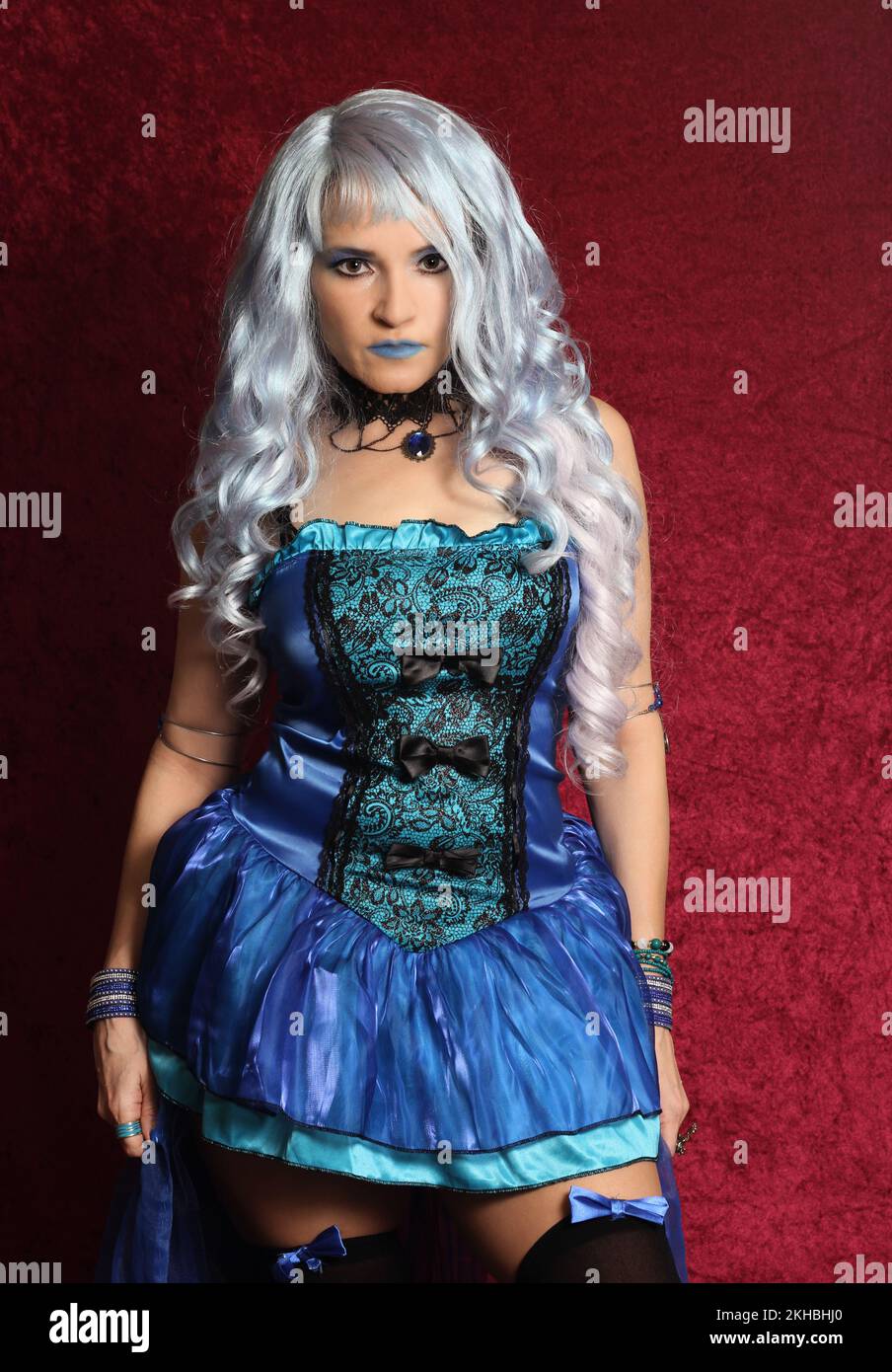 Woman With Blue Hair and Blue Corset Dress on Red Velvet Stock Photo