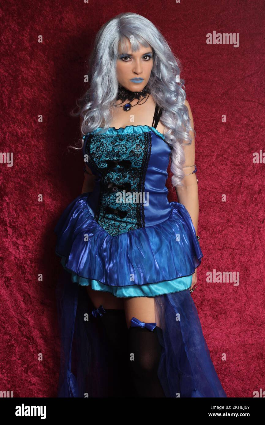 Woman With Blue Hair and Blue Corset Dress on Red Velvet Stock Photo