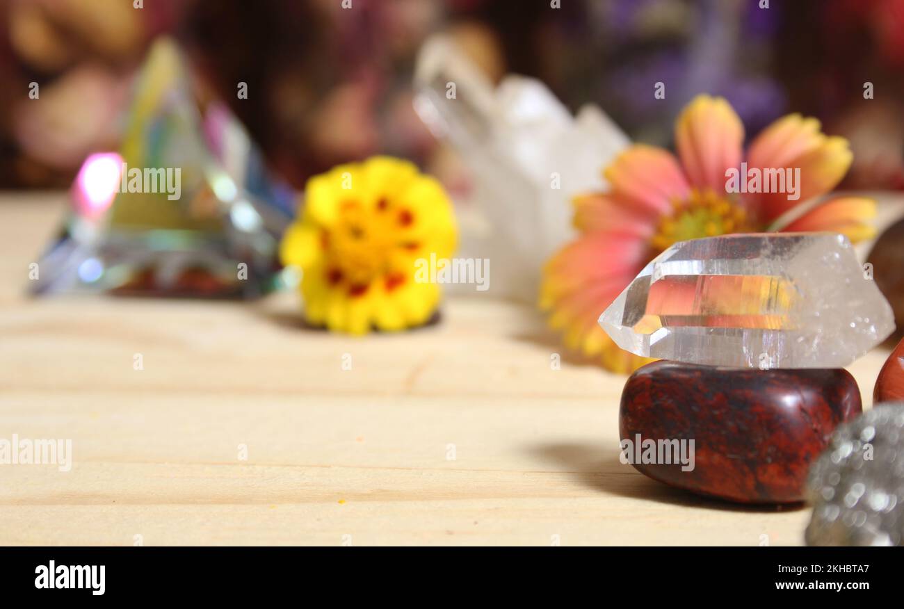 Quartz Crystal Balanced on Bloodstone With Flowers in Background Stock Photo