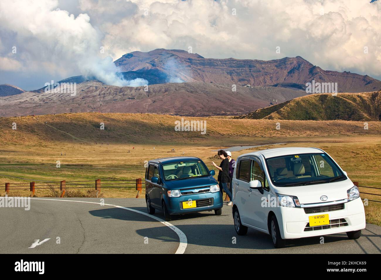 Tourists stop to watch smoke and steam rise from Mt. Aso volcano ...