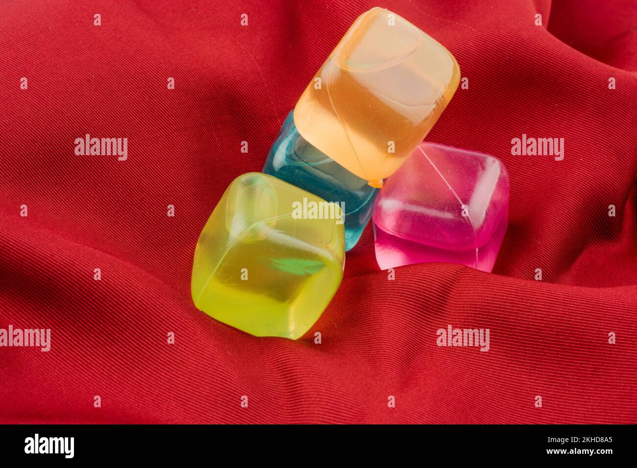 Fake ice cubes in color on a colorful fabric background Stock Photo Alamy