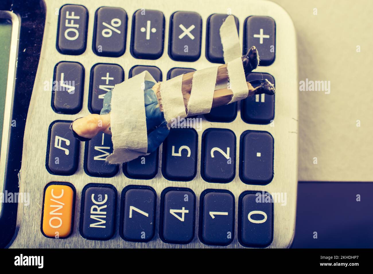 Tiny figurine of man model wrapped in bandages calculator Stock Photo