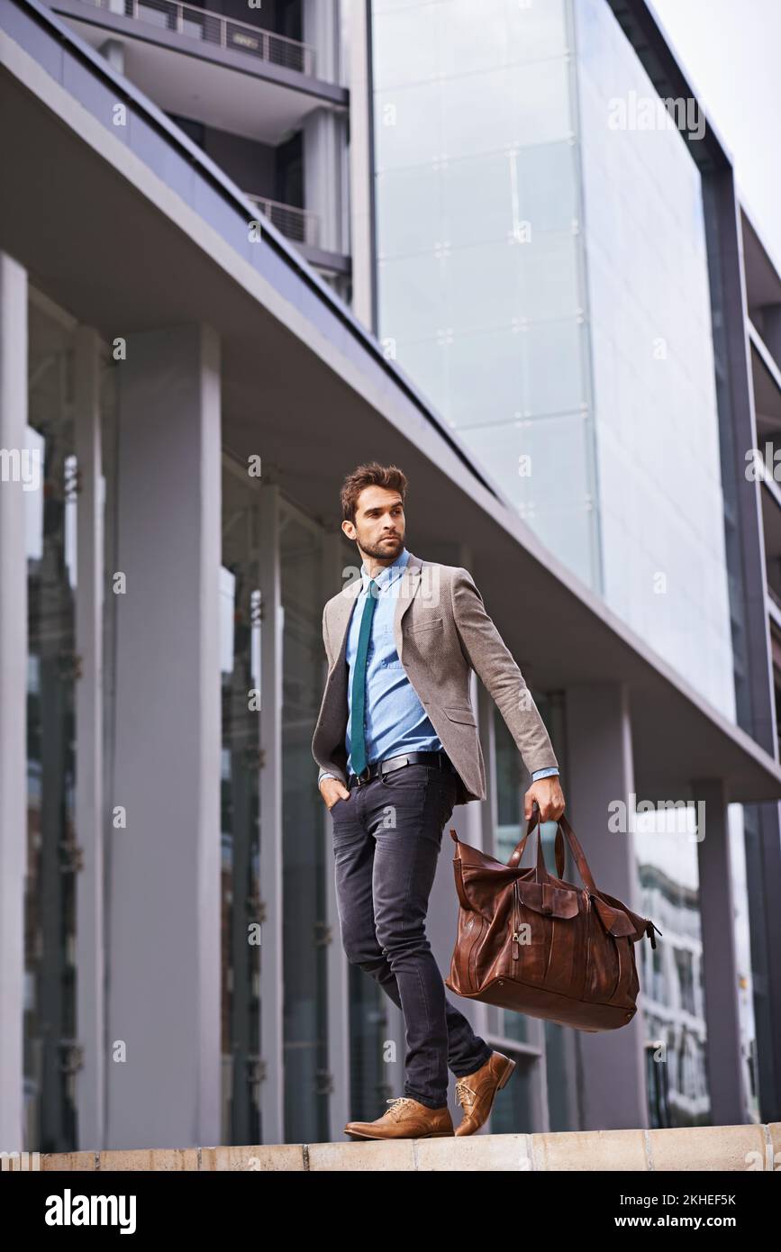 Styled for success. Portrait of a handsome and stylish young businessman walking in an urban setting. Stock Photo