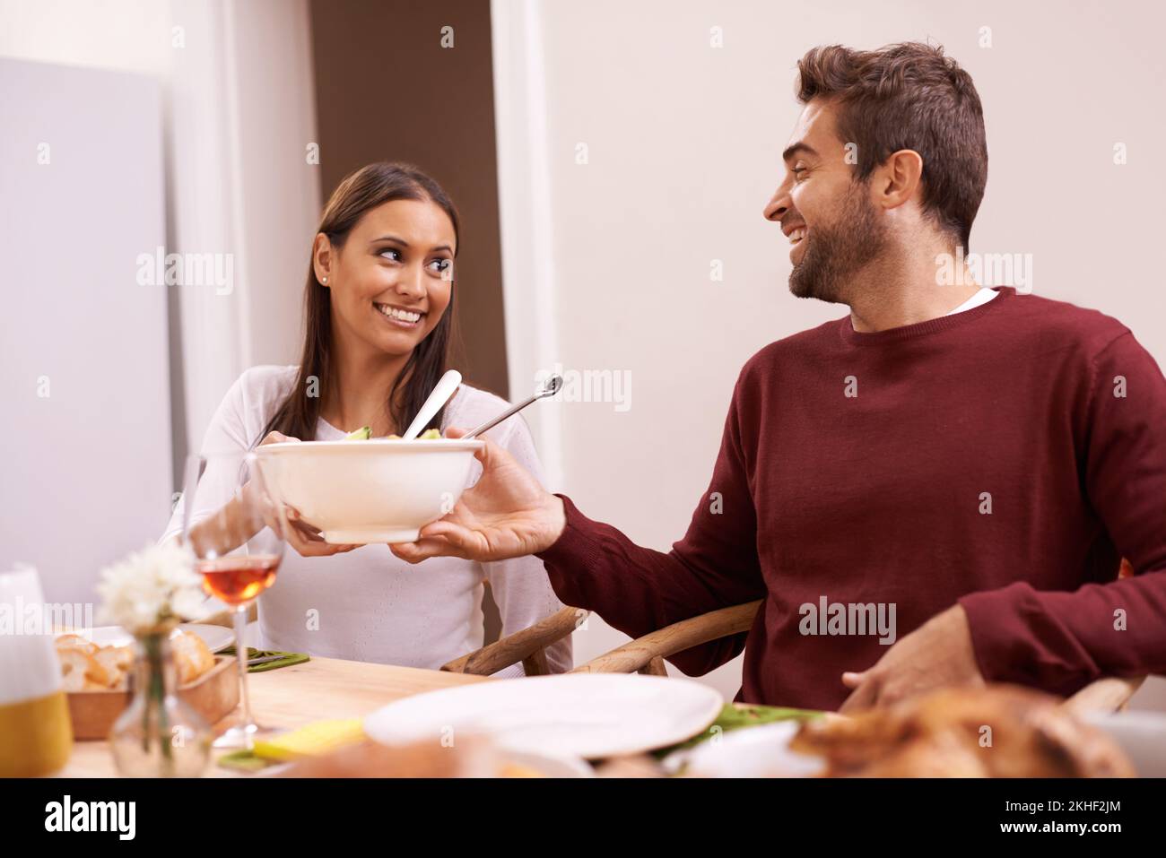 Hes such a gentlemen. A happy couple enjoying a family meal around the table. Stock Photo